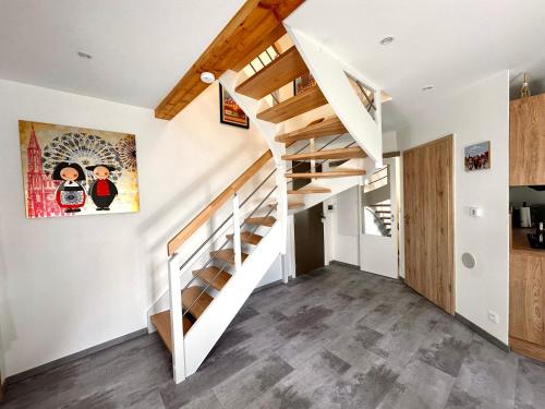 a staircase in a home with white walls and wooden floors at Duplex confort exceptionnel hyper centre parking à proximité in Haguenau