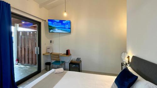 a bedroom with a bed and a window and a desk at Sonrisa Boutique Hotel - Adults Only in Kralendijk
