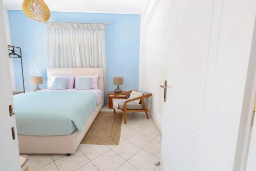 a blue bedroom with a bed and a chair at My Greek Oasis in Loutraki