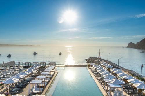 a pool with chairs and umbrellas in the water at Breathless Cabo San Lucas - Adults Only in Cabo San Lucas