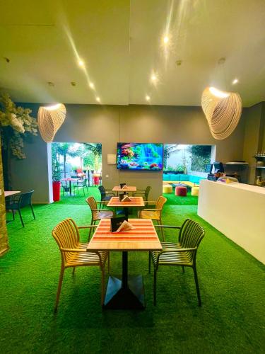 a restaurant with tables and chairs and a green floor at Rent-inn Boutique Hotel in Rabat