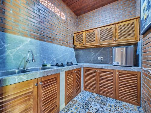 eine Küche mit Holzschränken und einer Spüle in der Unterkunft Kanchana Cottages in Uluwatu