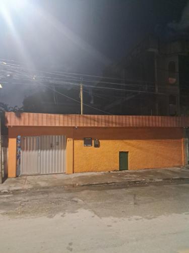 a building with a gate and a garage at night at Hostel & Pousada UFPE INN in Recife