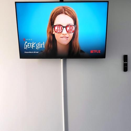 une télévision avec une femme portant des lunettes dans l'établissement Résidence du Lac-Disneyland Paris-TARIF FAMILIAL, à Émerainville