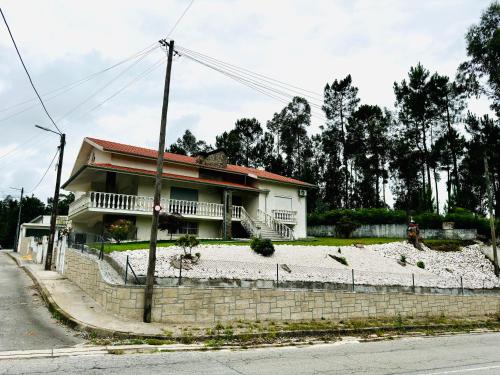 a house sitting on the side of a street at Oliveira Guest House in Louredo