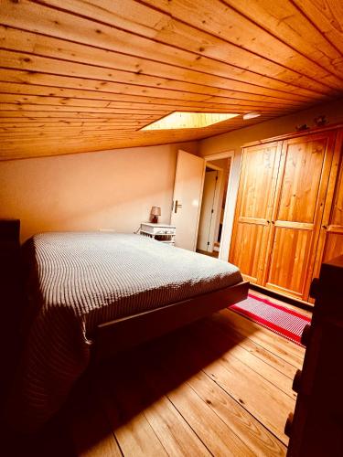 a bed in a room with a wooden ceiling at Oliveira Guest House in Louredo