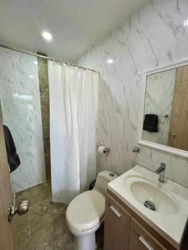 a white bathroom with a toilet and a sink at Mountain View Pool & Slide AC 5min to Town in Santa Fe de Antioquia