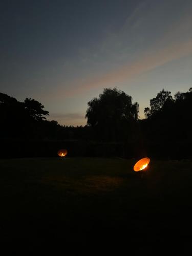 two orange lights in a field at night at TheLittleHouse-By-The-Lake in Hørsholm