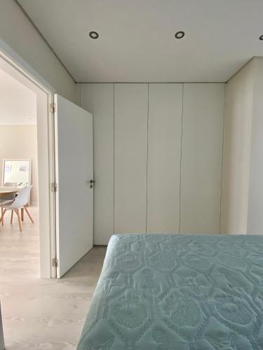 a bedroom with white wardrobes and a bed at Barra Azul - Beach Apartment in Praia da Barra