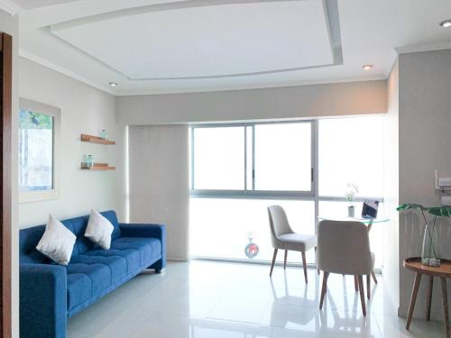 a living room with a blue couch and a table at Depa de lujo con piscina y jacuzzi in Guayaquil