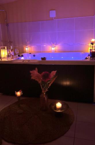 a bathroom with a tub with purple lighting at Grande maison romantique avec jacuzzi intérieur & parking, à 1h30 de Paris in Montbouy