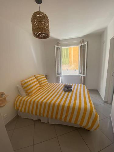 - une chambre avec un lit rayé jaune et blanc dans l'établissement Au cœur de Cassis, à Cassis
