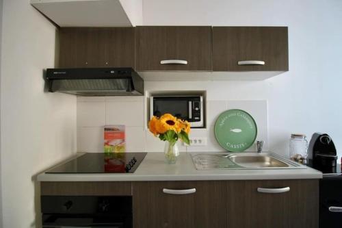 une cuisine avec un vase de fleurs sur un comptoir dans l'établissement Au cœur de Cassis, à Cassis