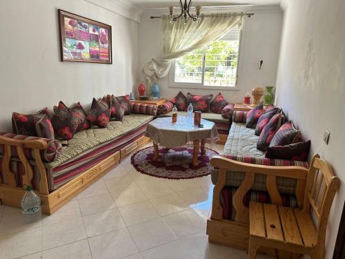 a living room with a couch and a table at Forest near to the beach امام المستشفى الجامعي طنجة in Daidatz