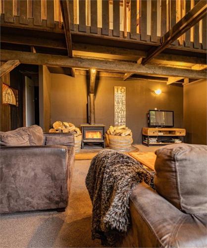 a living room with two couches and a fireplace at The Shed in Rangataua