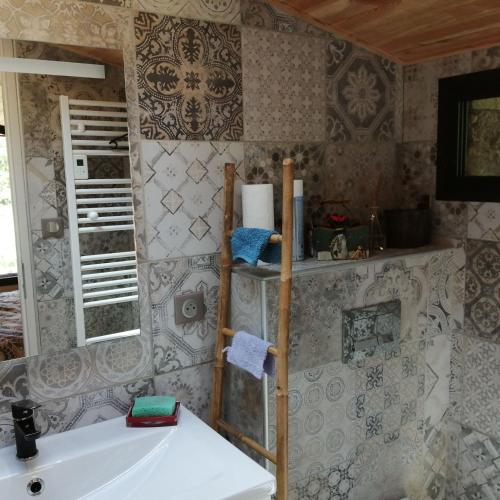 La salle de bains est pourvue d'un lavabo et de carrelage. dans l'établissement La bergerie d'antan, à Castelreng