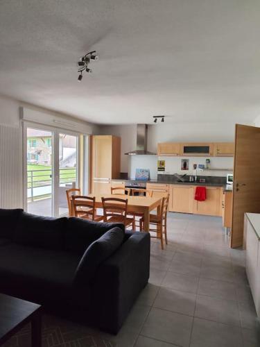 un salon avec une table et une cuisine dans l'établissement Appartement Résidence Le Beau Site, à Métabief