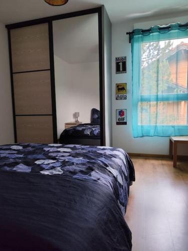 une chambre avec un lit et une fenêtre avec des rideaux bleus dans l'établissement Appartement Résidence Le Beau Site, à Métabief