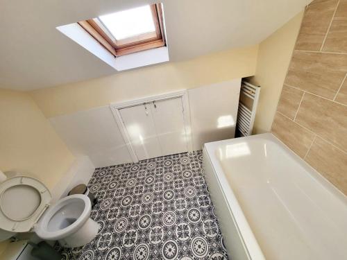 a small bathroom with a toilet and a bath tub at Stay Sleep Rest - Oldham in Oldham