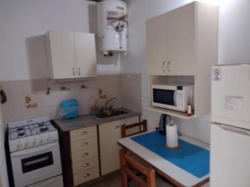 a kitchen with white cabinets and a stove top oven at DEPARTAMENTO EN LOMA HERMOSA 2 in Loma Hermosa