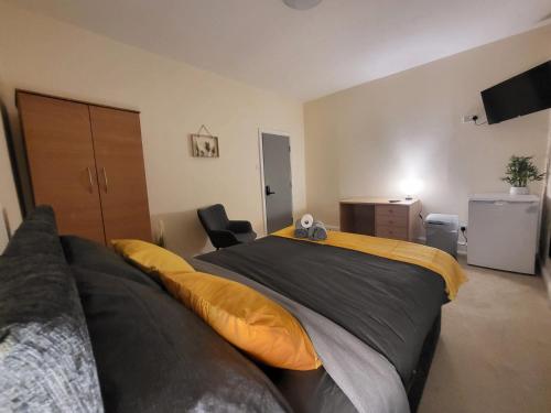 a bedroom with a large bed with yellow pillows at Stay Sleep Rest - Oldham in Oldham