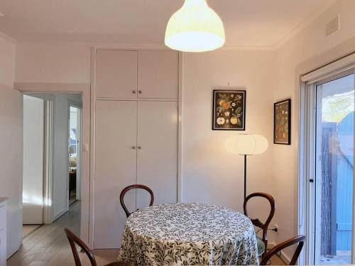 a dining room with a table and chairs and a lamp at Sunny Retro Home Burnside area in Rose Park