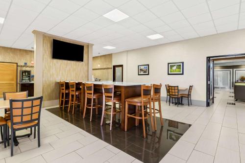 a large dining room with a bar with chairs at Best Western - Fayetteville in Fayetteville
