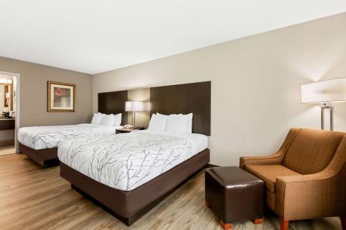 a hotel room with two beds and a chair at Best Western - Fayetteville in Fayetteville