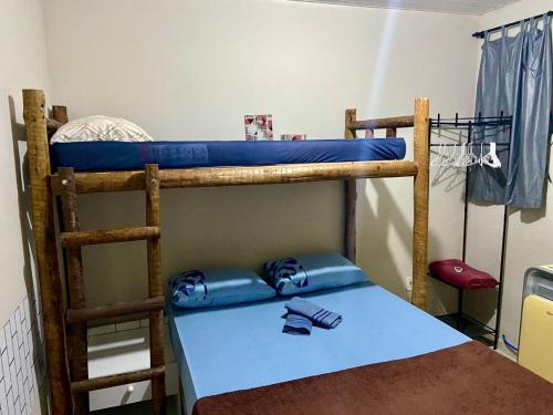 two bunk beds in a room with a blue table at Casa top aeroporto in Macaé