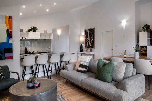 a living room with a couch and a table at Delfryn - stylish and modern, with great views in Daylesford