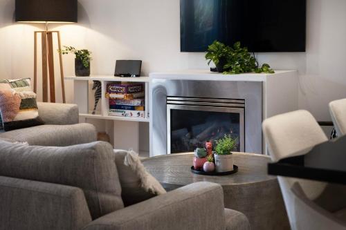 a living room with a table and a fireplace at Delfryn - stylish and modern, with great views in Daylesford