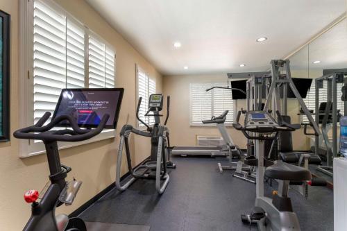 a gym with several tread machines and a tv at Best Western Plus Crown Colony Inn & Suites in Lufkin