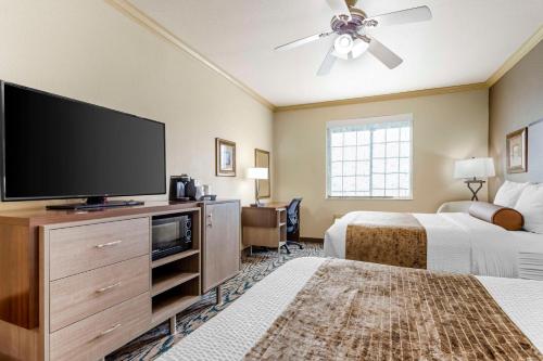 a hotel room with two beds and a flat screen tv at Best Western Plus Crown Colony Inn & Suites in Lufkin