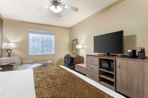 a hotel room with a bed and a flat screen tv at Best Western Plus Crown Colony Inn & Suites in Lufkin