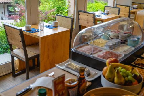 a table with a buffet of food in a restaurant at Best Western Bridge Hotel Lyon East in Jons