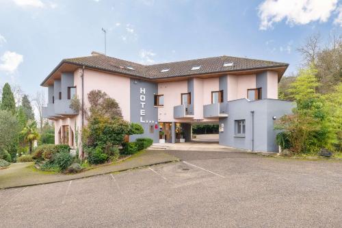 a large pink building with a parking lot at Best Western Bridge Hotel Lyon East in Jons