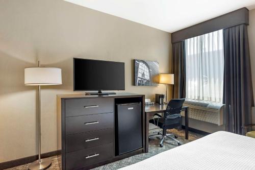 a hotel room with a bed and a desk with a television at Best Western Plus Philadelphia-Pennsauken Hotel in Cherry Hill