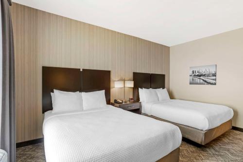 two beds in a hotel room with white sheets at Best Western Plus Philadelphia-Pennsauken Hotel in Cherry Hill