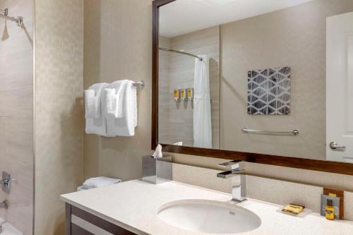 a bathroom with a sink and a large mirror at Best Western Plus Philadelphia-Pennsauken Hotel in Cherry Hill