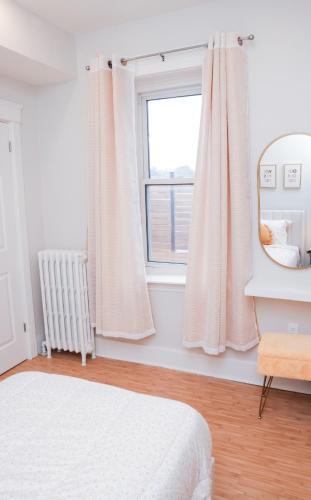 a white bedroom with a bed and a window at Upper Welly Retreat in Stratford