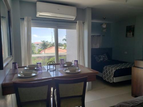 ein Zimmer mit einem Tisch und ein Schlafzimmer mit einem Bett in der Unterkunft DB Tower Vacation Rental in Belize City