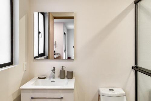 a white bathroom with a sink and a mirror at TONALA By Mr W in Mexico City