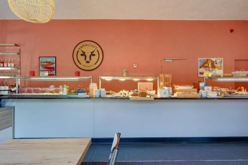 a counter in a restaurant with a clock on the wall at Sure Hotel by Best Western Annecy in Annecy