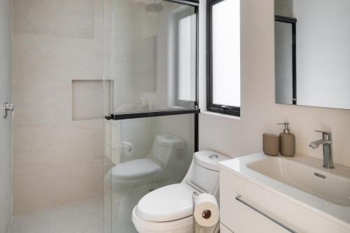 a white bathroom with a toilet and a sink at TONALA By Mr W in Mexico City