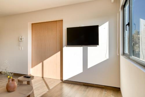 a living room with a flat screen tv on a wall at TONALA By Mr W in Mexico City