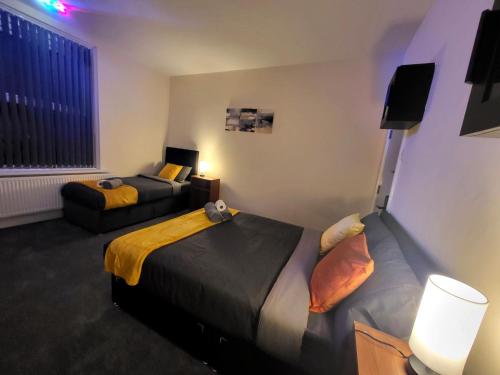 a hotel room with two beds and a couch at Stay Sleep Rest - Oldham in Oldham