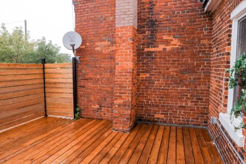 an outdoor deck with a brick wall and a basketball hoop at Upper Welly Retreat in Stratford
