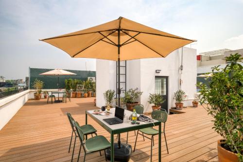 a patio with a table and an umbrella on a roof at TONALA By Mr W in Mexico City