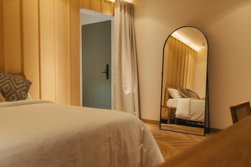 a bedroom with a bed and a large mirror at Hotel Boutique Roomzz Laureles in Medellín