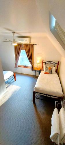 a bedroom with a large bed and a window at Woodlane Cottages Hunter Valley in Lovedale